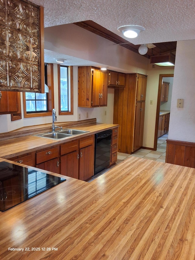 kitchen featuring beverage cooler, wooden counters, a textured ceiling, and a sink