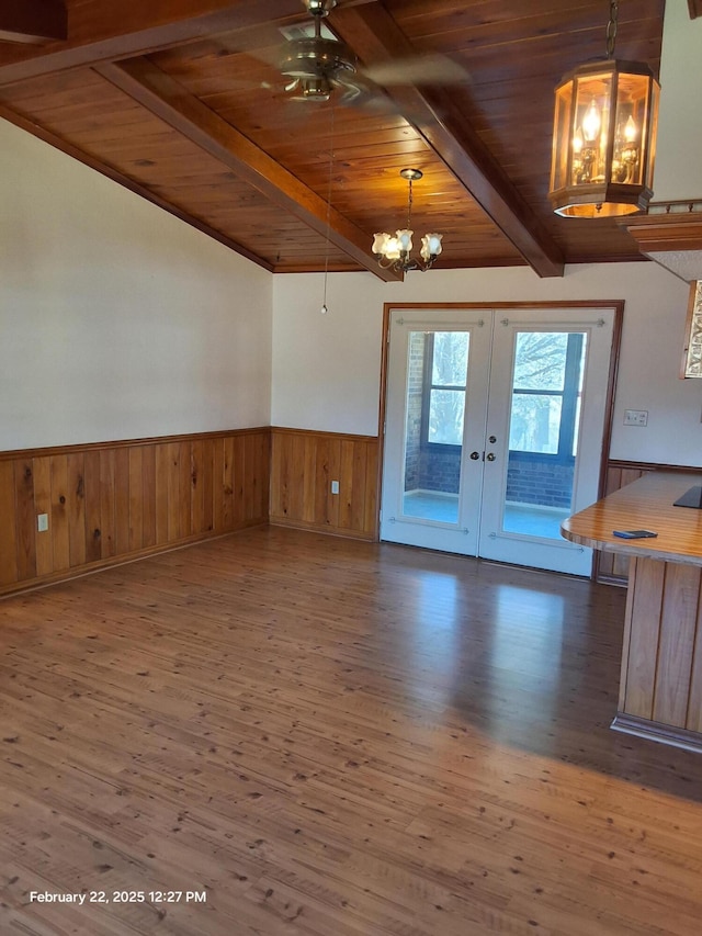 interior space featuring a notable chandelier, dark wood-style flooring, wood ceiling, french doors, and wainscoting