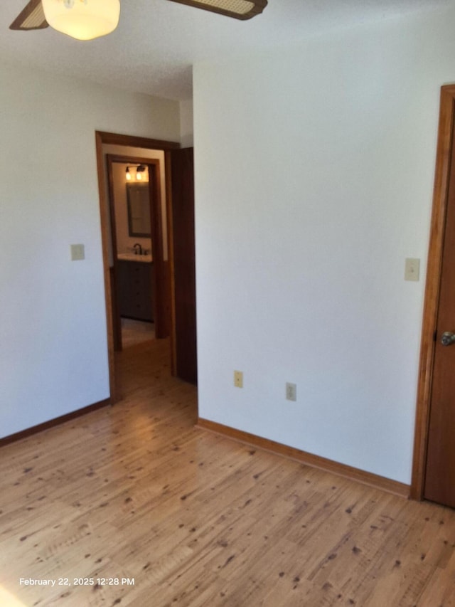 unfurnished room with light wood-style floors, baseboards, and a ceiling fan