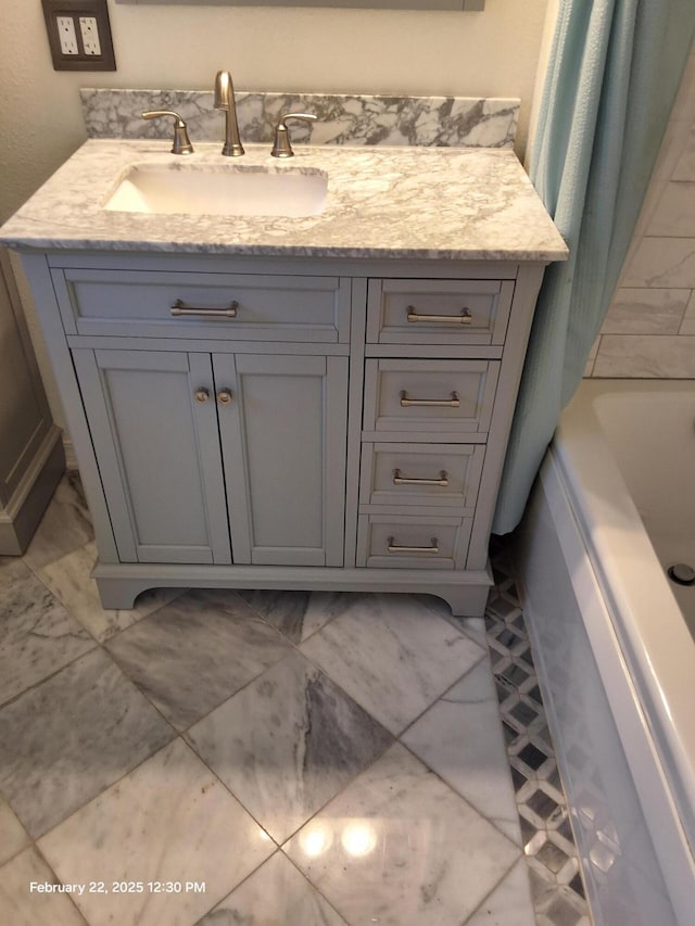 full bathroom featuring marble finish floor and vanity