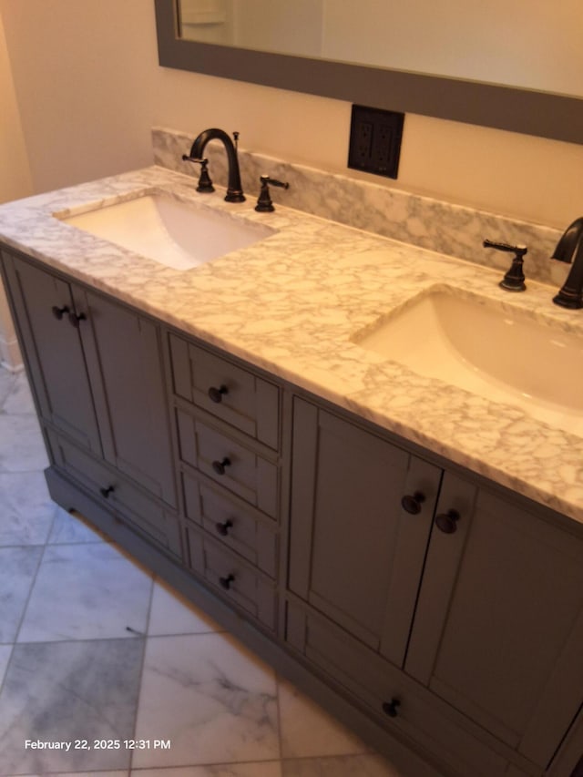 bathroom with double vanity, marble finish floor, and a sink