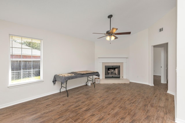 living room with dark wood-style floors, ceiling fan, baseboards, and a tile fireplace