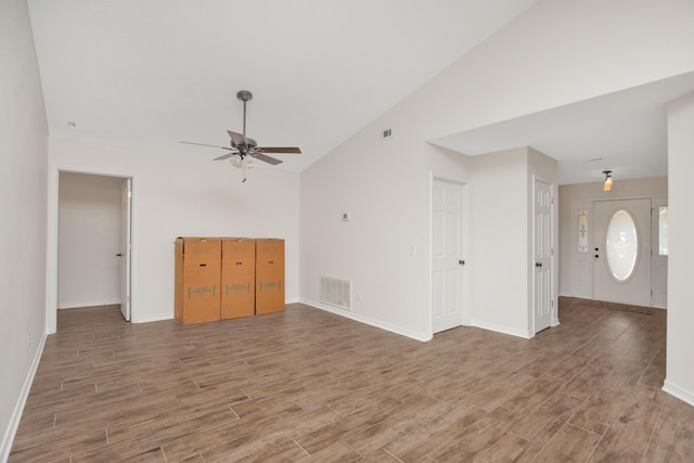 unfurnished living room featuring a ceiling fan, lofted ceiling, visible vents, and wood finished floors