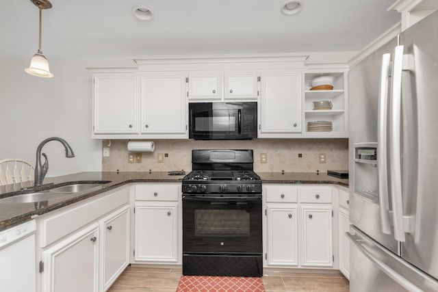 kitchen featuring a sink, white cabinetry, hanging light fixtures, black appliances, and dark stone countertops