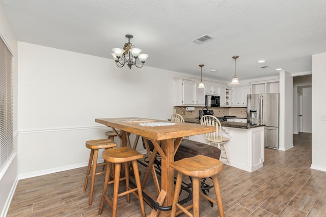 dining room featuring a chandelier, recessed lighting, visible vents, baseboards, and dark wood finished floors