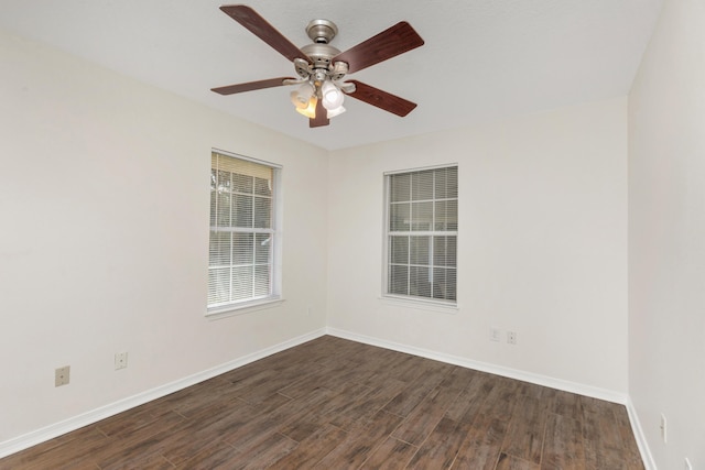 spare room with a ceiling fan, dark wood finished floors, and baseboards