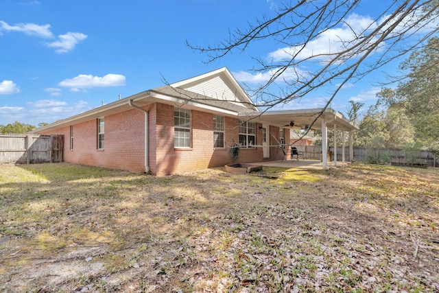 back of property with a yard, a fenced backyard, brick siding, and a patio