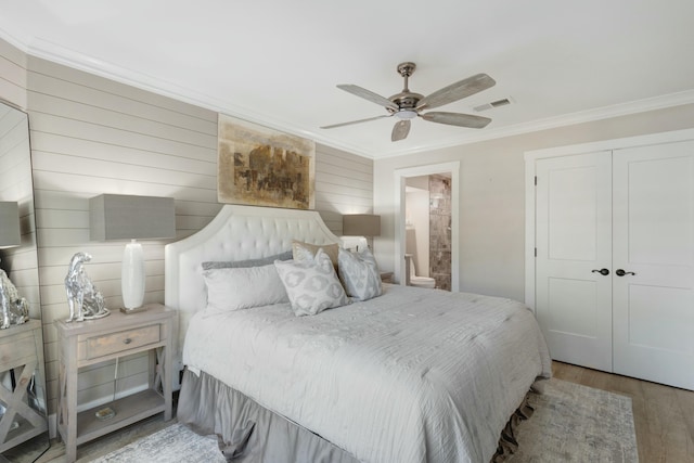 bedroom with ceiling fan, wood finished floors, visible vents, ornamental molding, and a closet