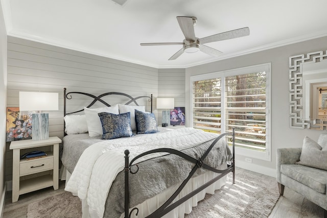 bedroom with ornamental molding, a ceiling fan, multiple windows, and wood finished floors