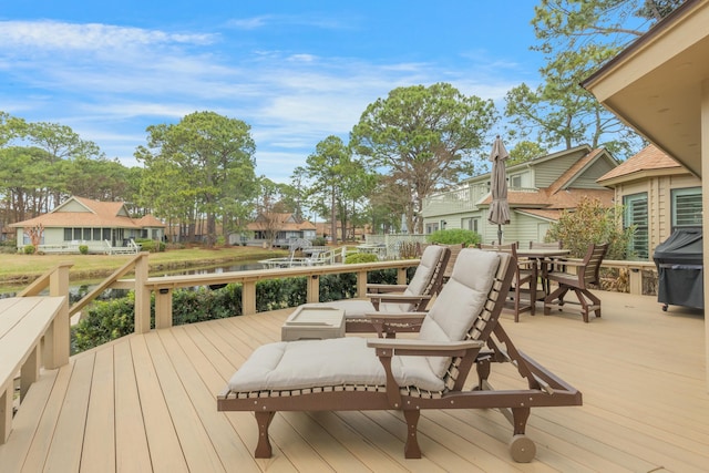 wooden terrace featuring a grill, a residential view, and outdoor dining area