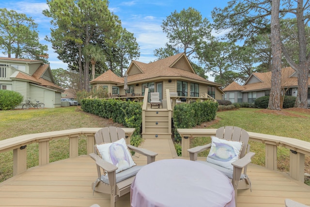 wooden deck featuring stairs, a lawn, and a residential view