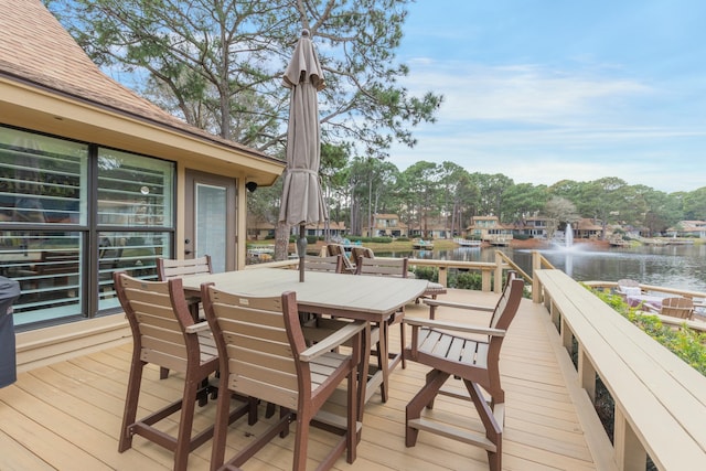 wooden terrace with outdoor dining area and a water view