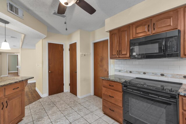 kitchen featuring black appliances, visible vents, and brown cabinetry