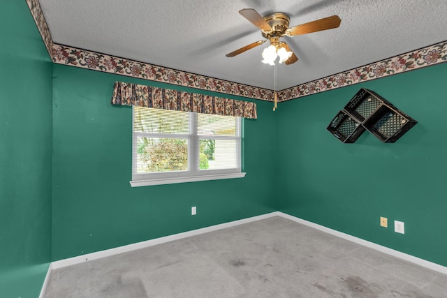 carpeted spare room featuring a textured ceiling, a ceiling fan, and baseboards