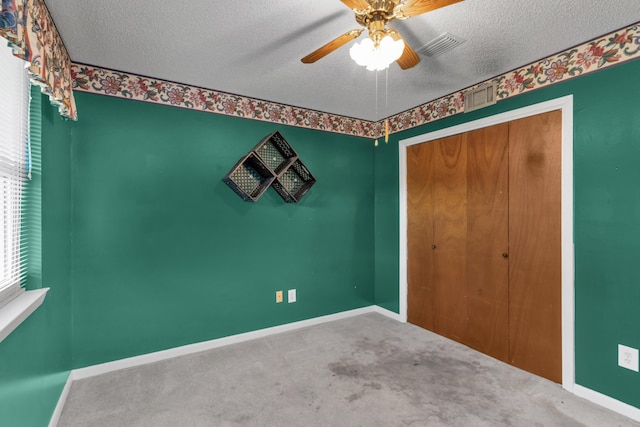 unfurnished bedroom with carpet floors, baseboards, and a textured ceiling