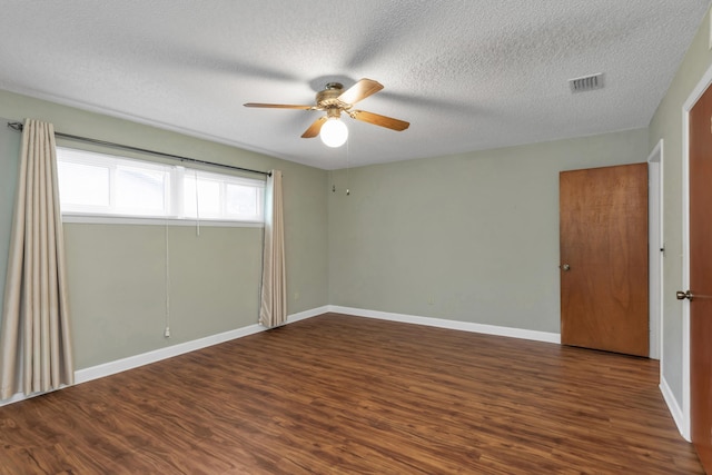 empty room featuring visible vents, baseboards, and wood finished floors