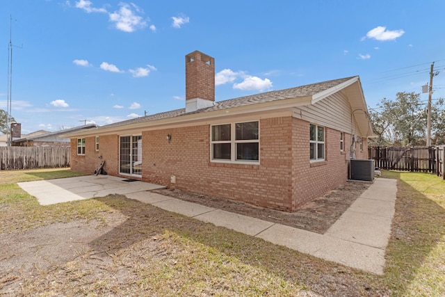 back of house featuring a patio, a chimney, fence private yard, central AC, and brick siding