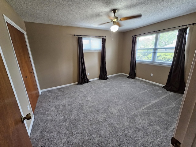 129 12th Ave, Shalimar, FL 32579 - unfurnished bedroom featuring a textured ceiling, multiple windows, ceiling fan, and carpet
