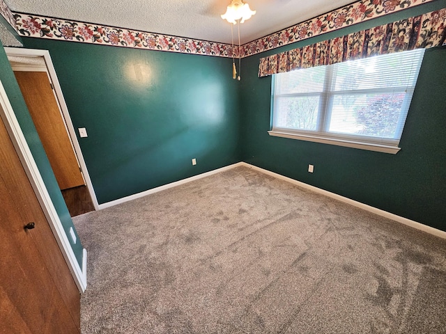 129 12th Ave, Shalimar, FL 32579 - carpeted spare room with baseboards and a textured ceiling