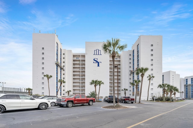 view of property with uncovered parking and a city view