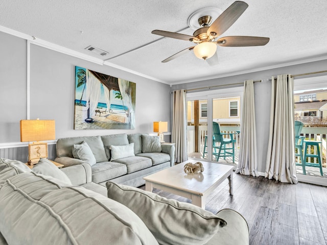 living room with visible vents, crown molding, a textured ceiling, and wood finished floors