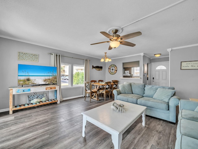 living area with ceiling fan, crown molding, baseboards, and wood finished floors