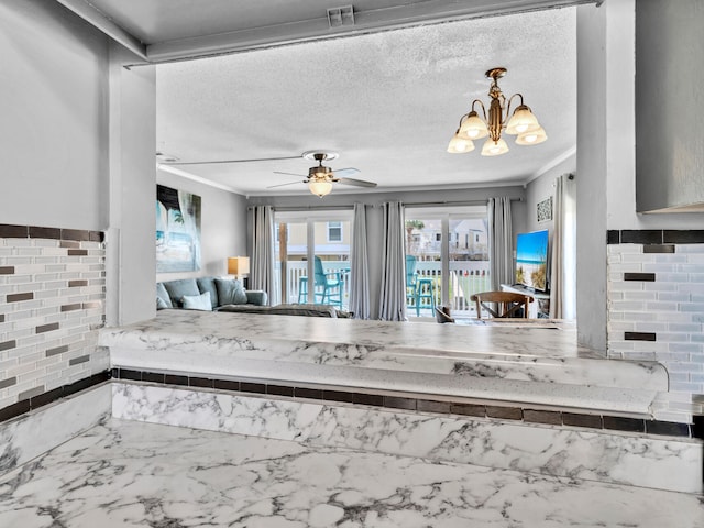 kitchen featuring a textured ceiling, ceiling fan with notable chandelier, visible vents, open floor plan, and marble finish floor