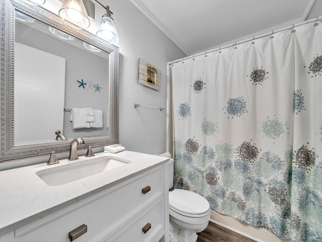 bathroom featuring toilet, shower / tub combo with curtain, wood finished floors, and vanity