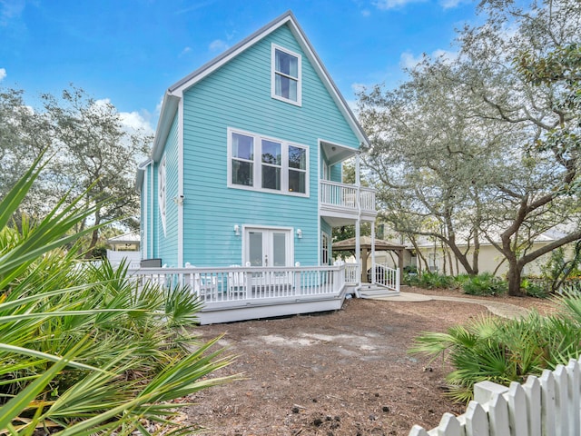 back of house with french doors and a balcony