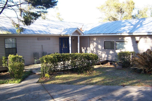 single story home featuring metal roof