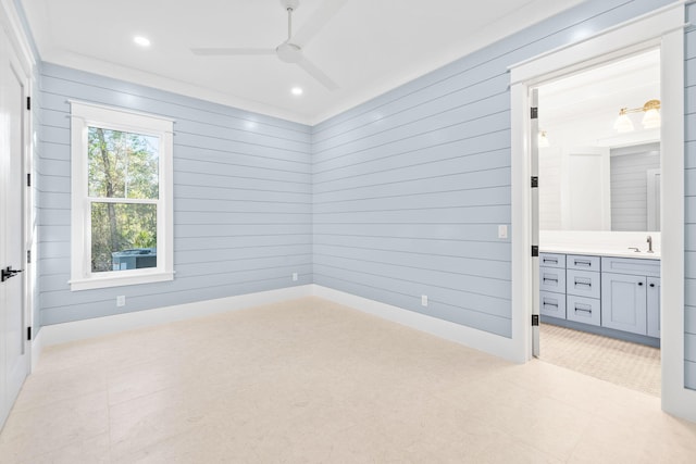 empty room with baseboards, wooden walls, a ceiling fan, and recessed lighting