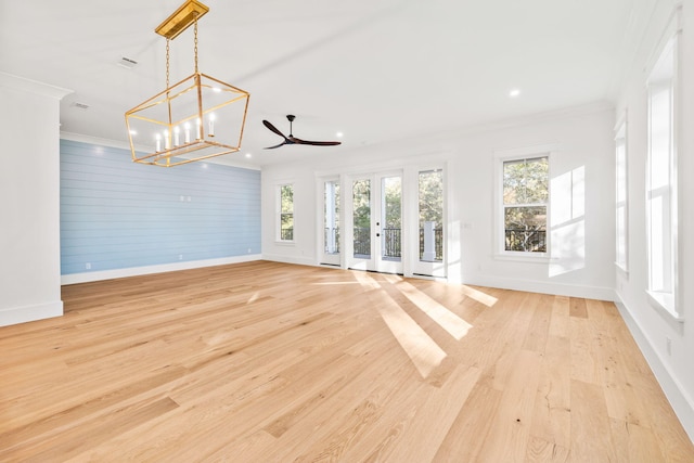 unfurnished living room with french doors, baseboards, crown molding, and light wood finished floors