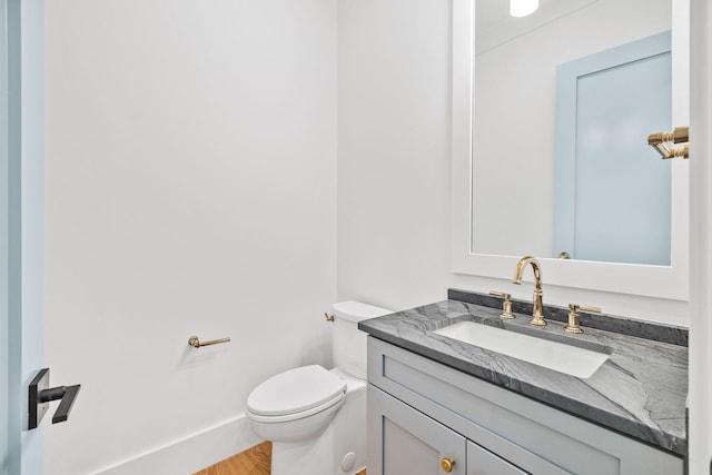 bathroom with wood finished floors, vanity, and toilet