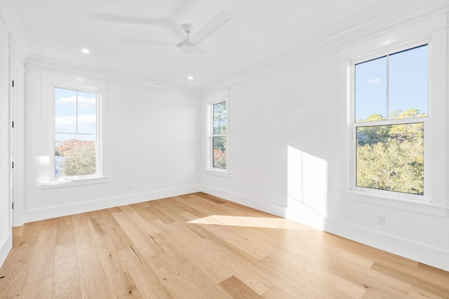 unfurnished room with a healthy amount of sunlight, crown molding, and light wood finished floors