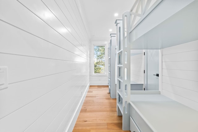 hallway with light wood-type flooring, ornamental molding, and recessed lighting