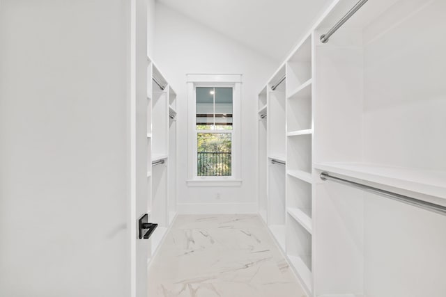 spacious closet featuring lofted ceiling and marble finish floor