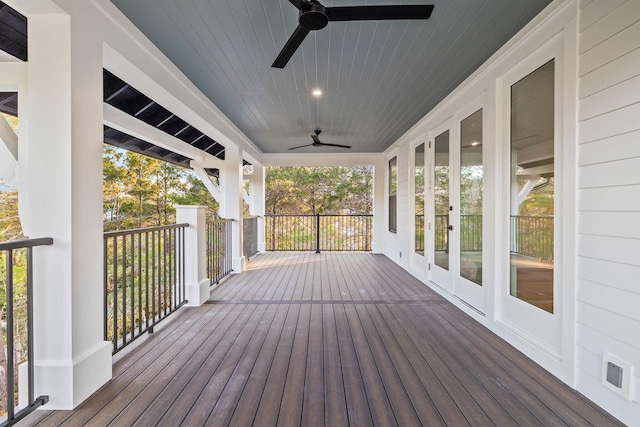 wooden terrace with a ceiling fan and visible vents