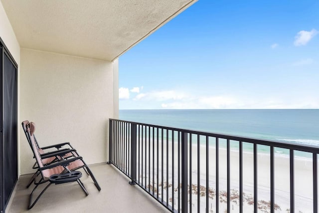 balcony featuring a water view and a beach view