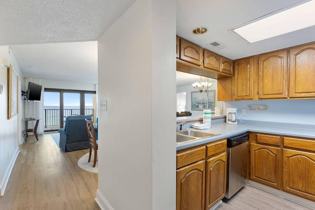 kitchen featuring dishwasher, light countertops, visible vents, and brown cabinets