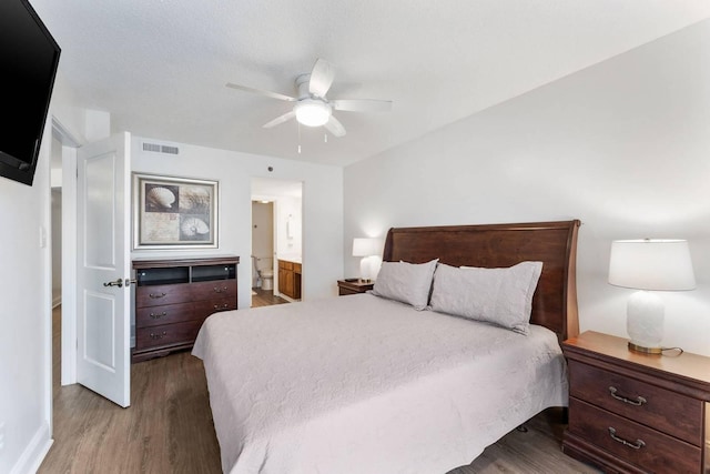 bedroom with a ceiling fan, visible vents, dark wood-style flooring, and ensuite bathroom