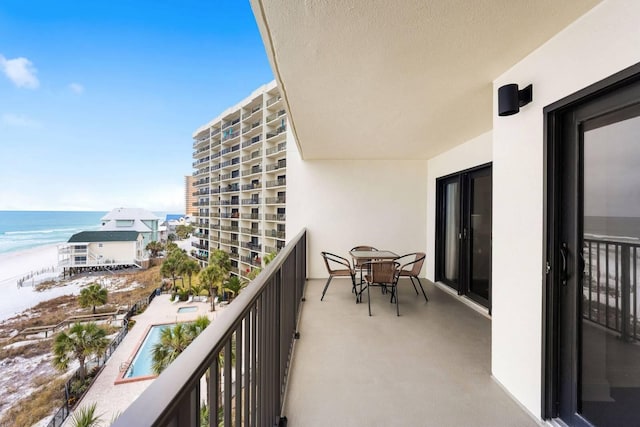 balcony featuring a water view and a beach view