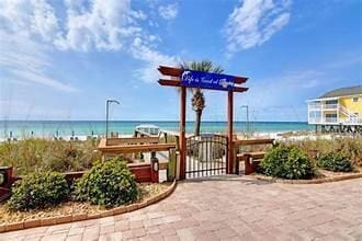 surrounding community with a water view, a gate, and a beach view