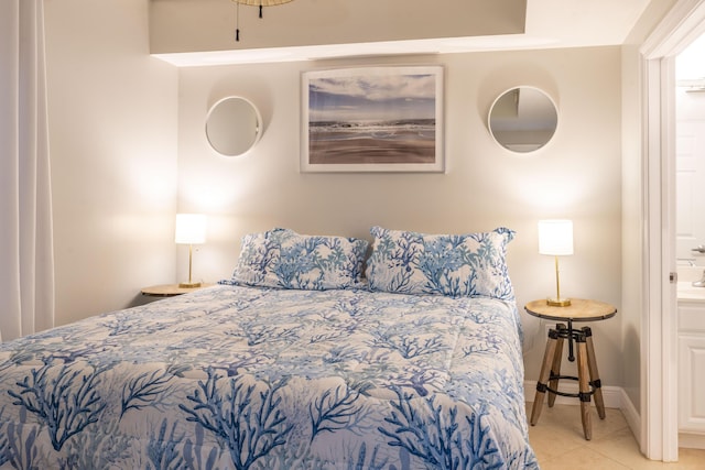 bedroom featuring baseboards, ensuite bathroom, and tile patterned floors