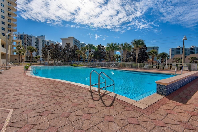 community pool featuring a patio and fence