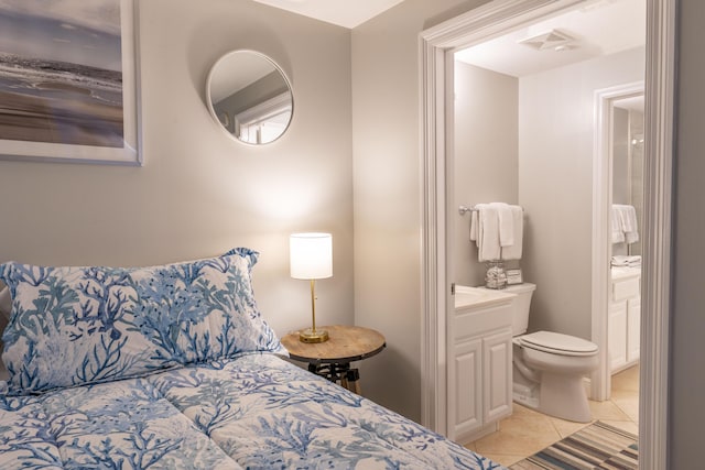 bedroom featuring visible vents, ensuite bath, and light tile patterned floors