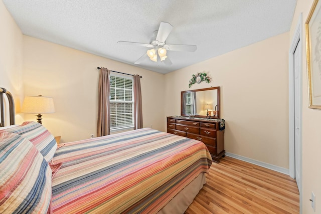 bedroom with a textured ceiling, ceiling fan, light wood-style flooring, and baseboards