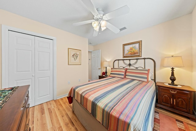 bedroom with light wood-style flooring, visible vents, baseboards, a ceiling fan, and a closet