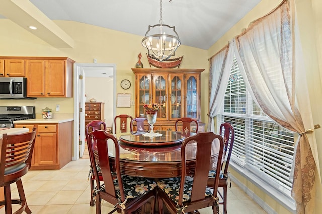 dining space featuring a chandelier, light tile patterned floors, and vaulted ceiling