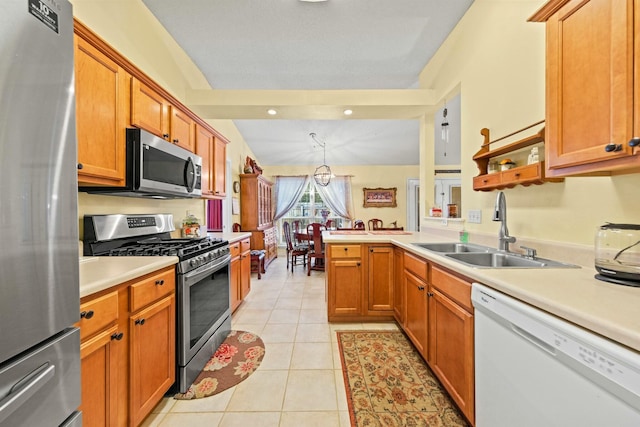 kitchen with decorative light fixtures, light countertops, appliances with stainless steel finishes, a sink, and a peninsula