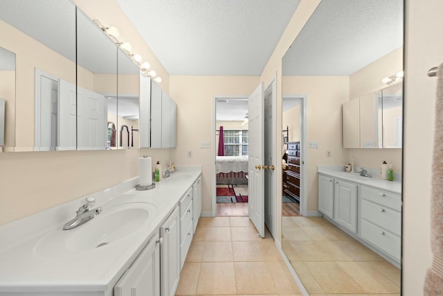 bathroom with tile patterned flooring, connected bathroom, a sink, and double vanity